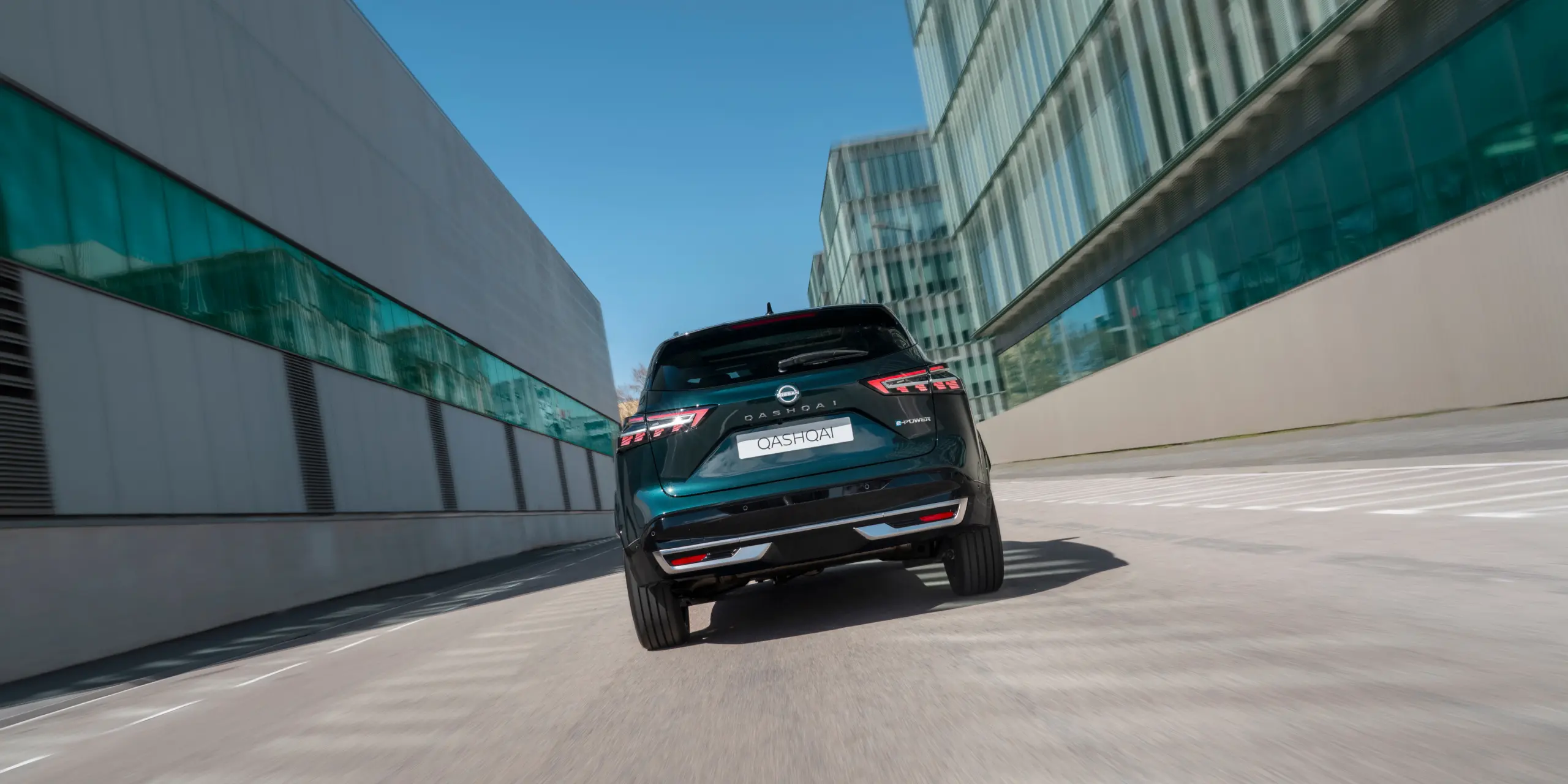 Rear view of Nissan Qashqai Hybrid SUV e‑POWER in a modern urban setting