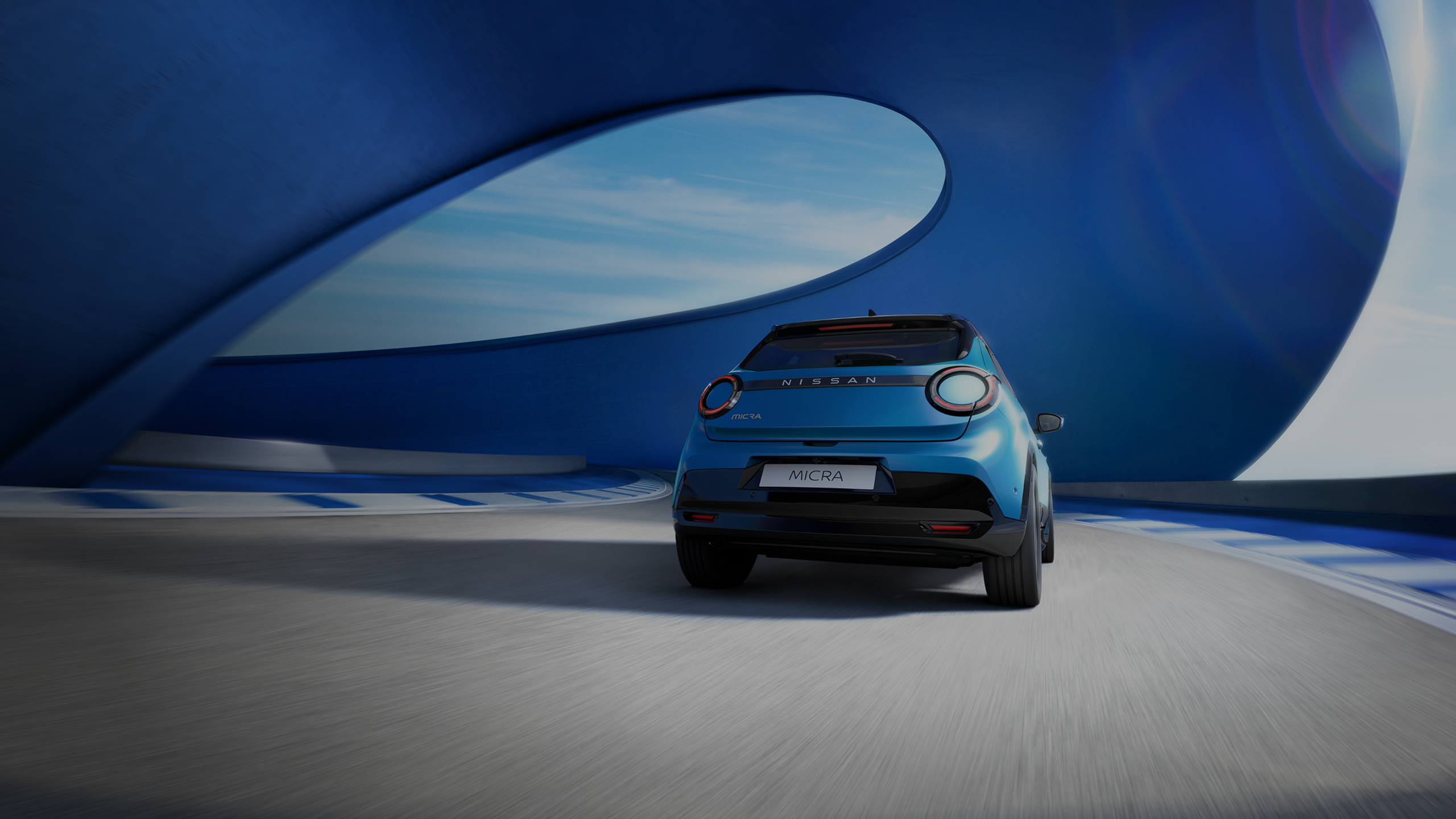 Vue arrière de la nouvelle Nissan MICRA sur une route sur un arrière plan bleu